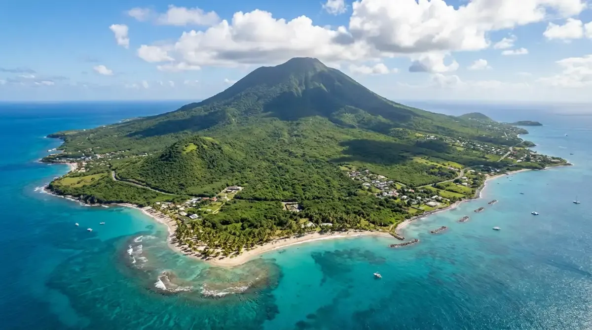 Aerial view of Nevis island showing volcanic peak rising from turquoise Caribbean waters, lush green tropical vegetation covering mountain slopes, pal