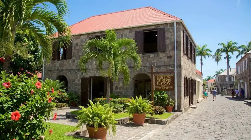 Museum of Nevis History building in Charlestown showing colonial Caribbean architecture with stone walls and wooden shutters, small tropical garden in