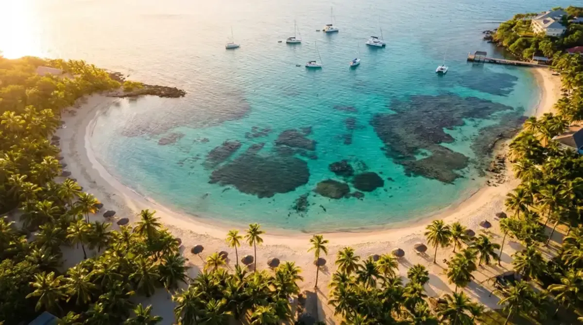 Aerial view of a Caribbean bay with crystal clear turquoise water showing coral reefs beneath the surface
