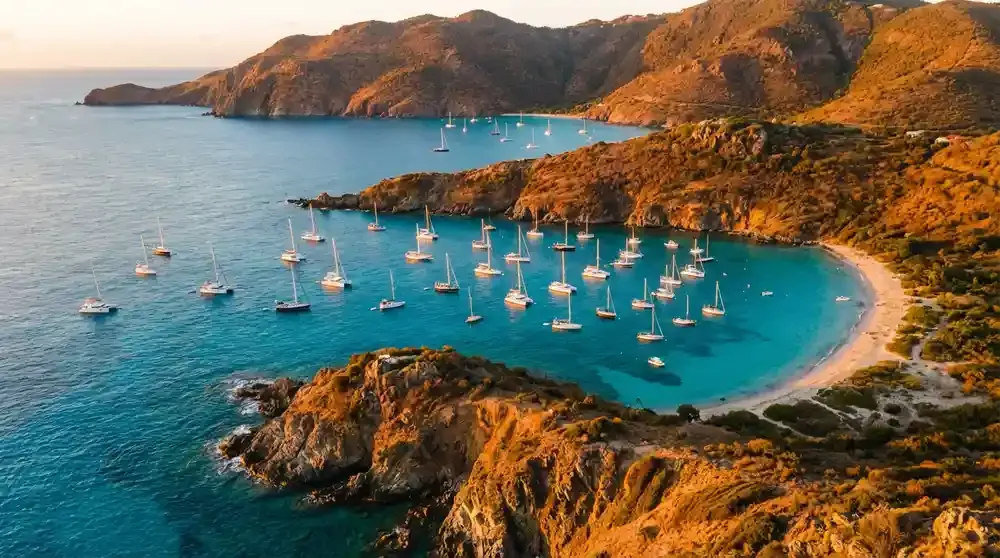 Gouverneur beach with steep green hills surrounding white sand beach